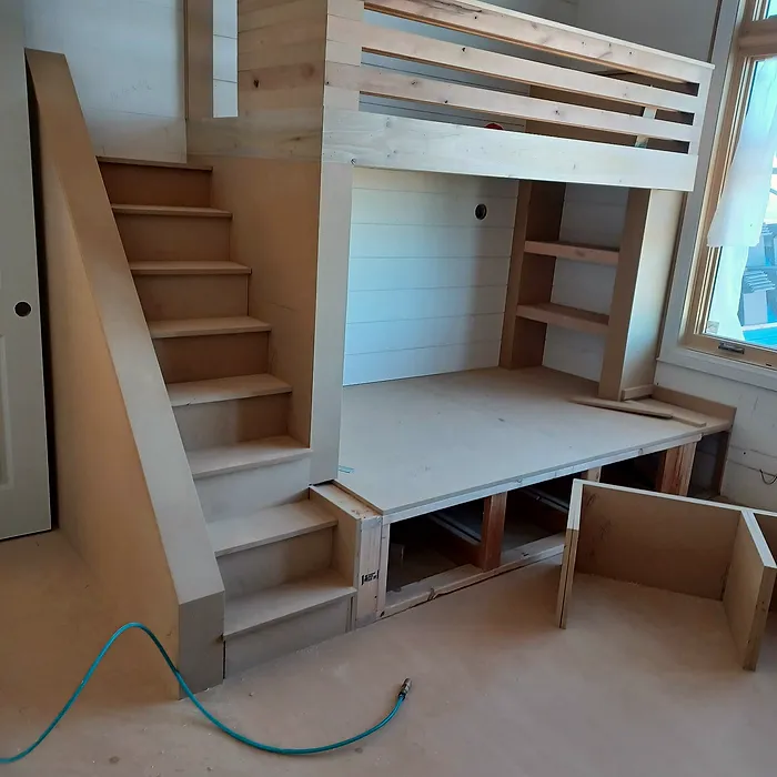 Custom loft bed with built-in stairs and a desk