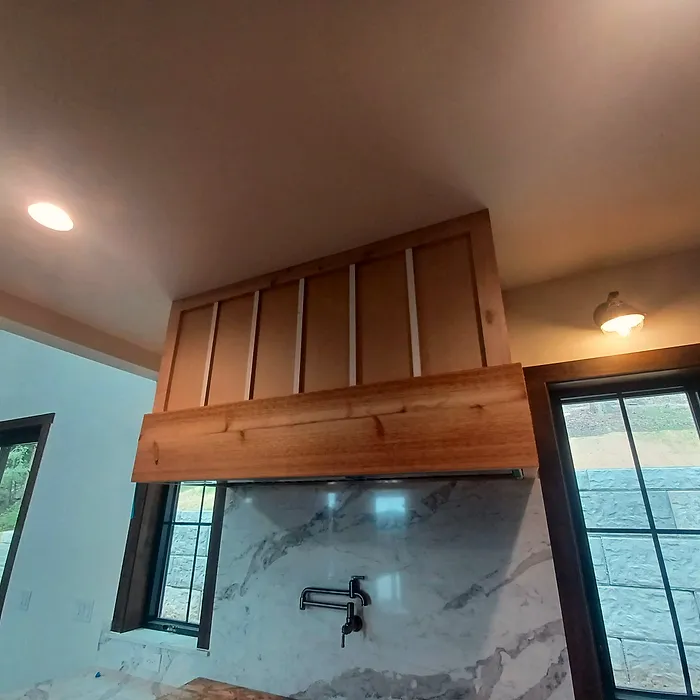 Wood ceiling beam and range-hood surround with window trim