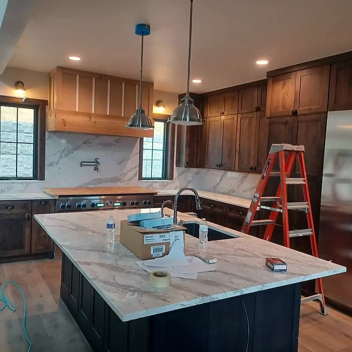 Kitchen with a marble island and a custom wood range hood